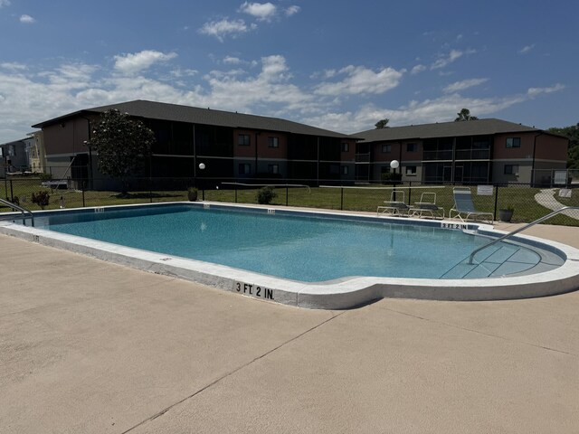 view of swimming pool with a yard