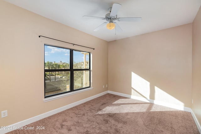 unfurnished room with ceiling fan and carpet