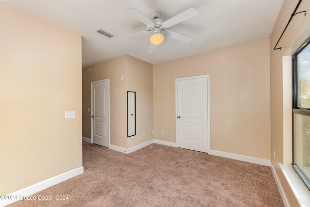 unfurnished room with ceiling fan and light carpet