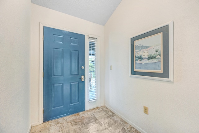 entryway featuring vaulted ceiling and light tile flooring