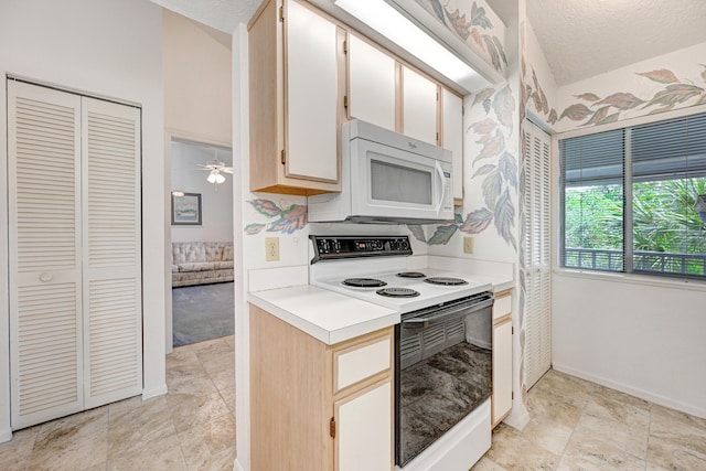 kitchen with light tile floors, ceiling fan, white appliances, and a textured ceiling