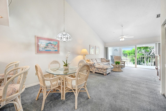 dining space featuring high vaulted ceiling, dark colored carpet, and ceiling fan