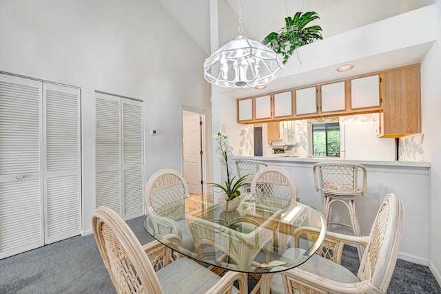 carpeted dining room featuring high vaulted ceiling and a notable chandelier