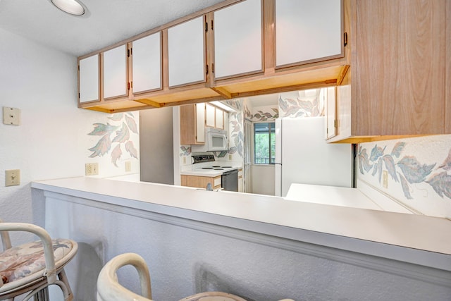 kitchen featuring white cabinets and white appliances