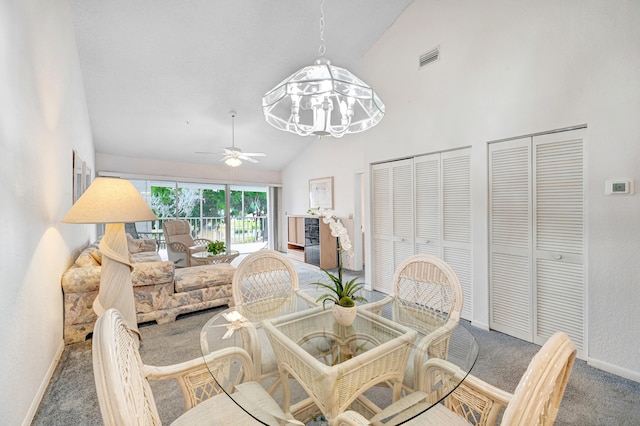 dining area featuring high vaulted ceiling, ceiling fan with notable chandelier, and dark colored carpet