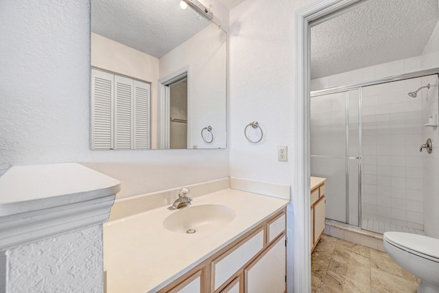 bathroom with tile floors, toilet, large vanity, and a textured ceiling