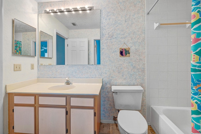 full bathroom featuring shower / bath combo, toilet, vanity, and a textured ceiling