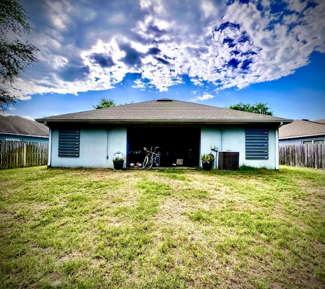 rear view of property with a lawn and central AC unit