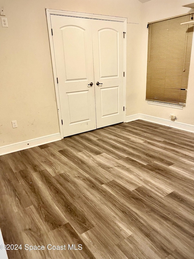 unfurnished bedroom with a closet and dark wood-type flooring