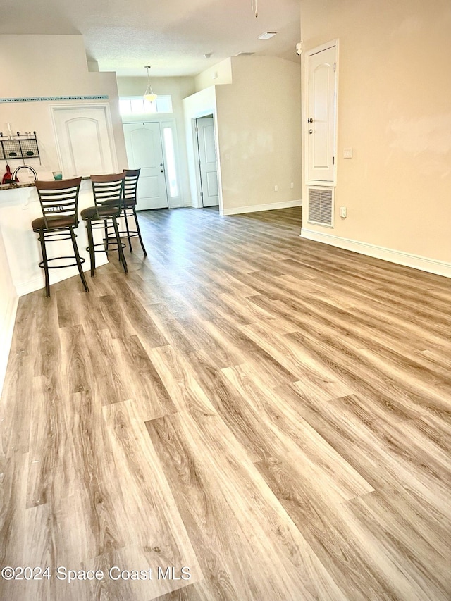 living room with a textured ceiling and light hardwood / wood-style flooring