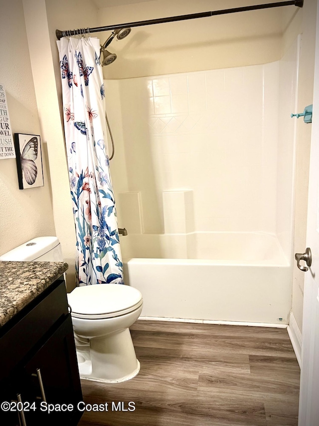 full bathroom featuring wood-type flooring, vanity, toilet, and shower / bath combo with shower curtain