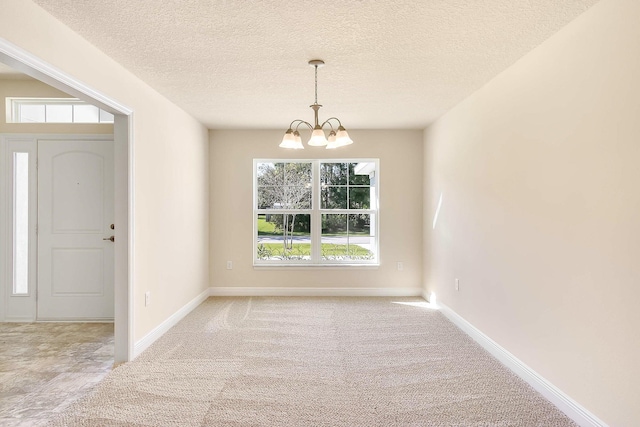 unfurnished dining area with a textured ceiling, light colored carpet, and a notable chandelier