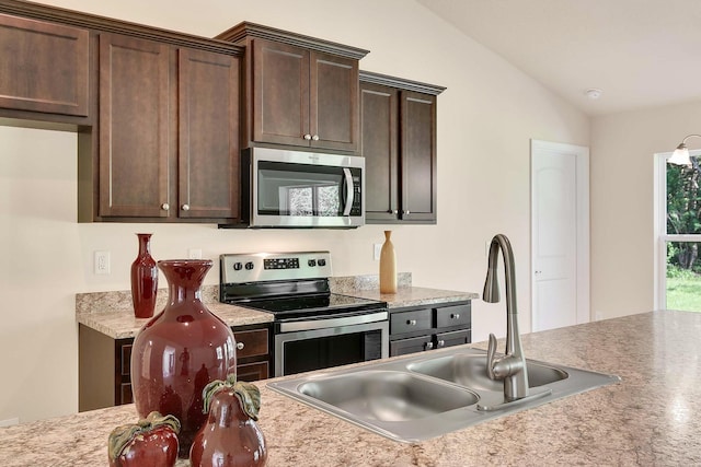 kitchen featuring sink, dark brown cabinetry, appliances with stainless steel finishes, and vaulted ceiling