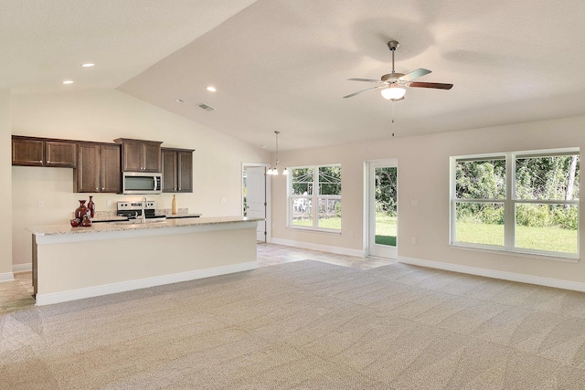 kitchen featuring ceiling fan with notable chandelier, light stone countertops, dark brown cabinetry, appliances with stainless steel finishes, and light carpet