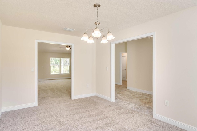 carpeted empty room with ceiling fan with notable chandelier and a textured ceiling