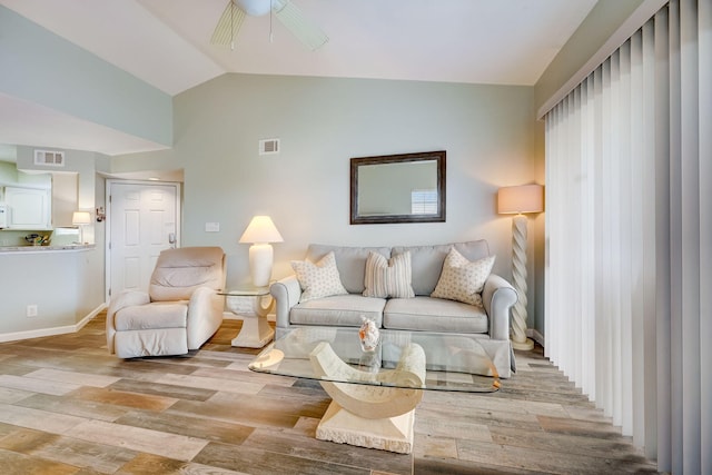 living room featuring vaulted ceiling, light wood-type flooring, and ceiling fan