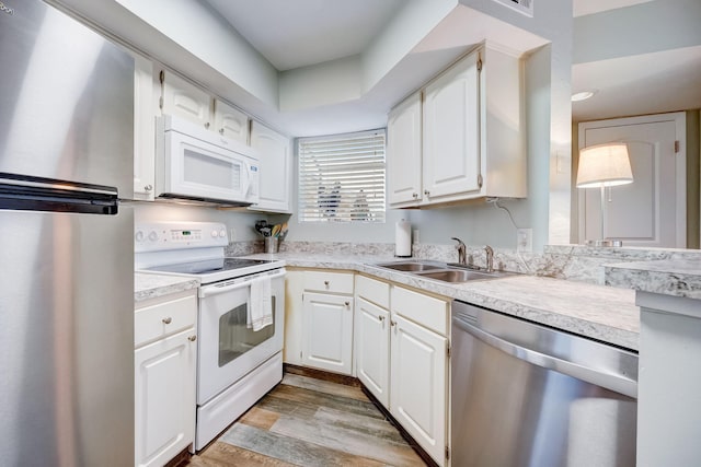 kitchen featuring sink, light hardwood / wood-style flooring, white cabinets, and stainless steel appliances