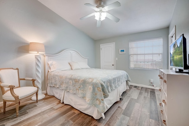 bedroom featuring ceiling fan, light hardwood / wood-style flooring, and lofted ceiling