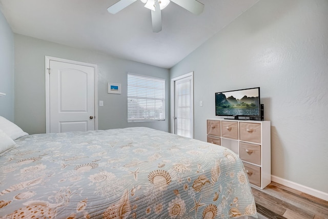 bedroom with hardwood / wood-style flooring, vaulted ceiling, and ceiling fan