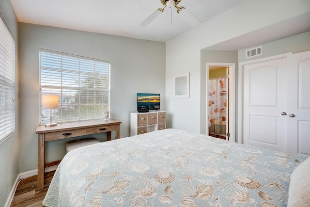 bedroom featuring wood-type flooring, a closet, ensuite bath, and ceiling fan