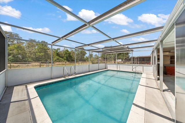 view of swimming pool featuring a patio area and glass enclosure