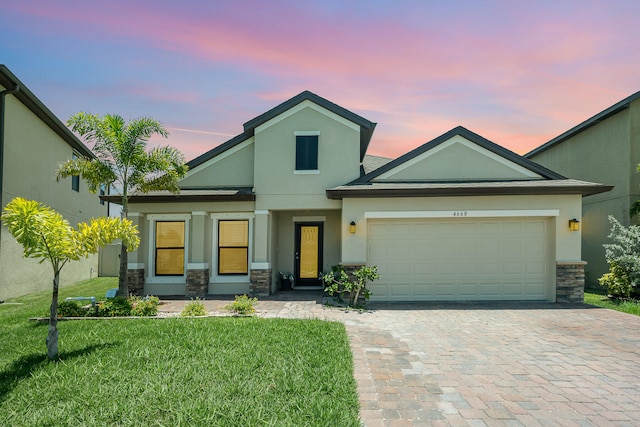 view of front of property with a yard and a garage