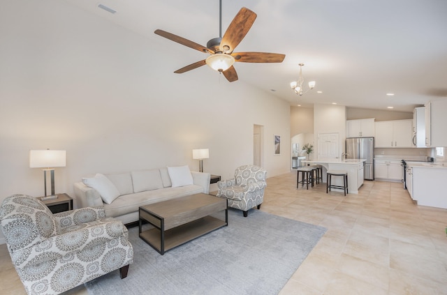 tiled living room with high vaulted ceiling and ceiling fan with notable chandelier