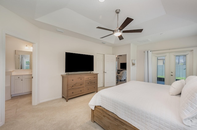 bedroom featuring ceiling fan, light colored carpet, ensuite bathroom, and french doors