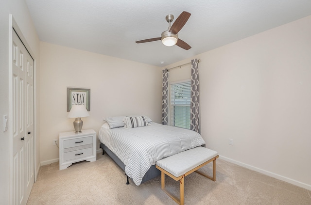 bedroom featuring ceiling fan, a closet, and light colored carpet