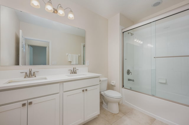 full bathroom with tile patterned floors, vanity, enclosed tub / shower combo, and toilet