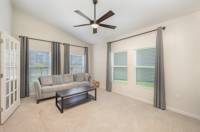 living room featuring light colored carpet, vaulted ceiling, and ceiling fan