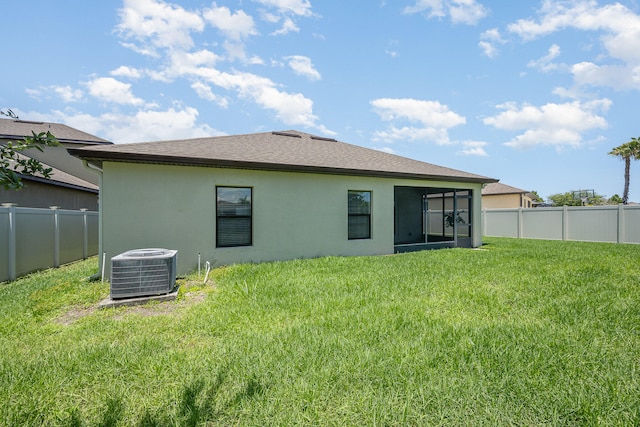 rear view of house with a yard and central AC unit