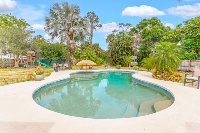 view of swimming pool with a patio and a playground