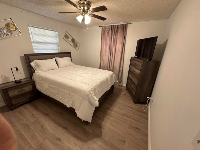 bedroom featuring wood-type flooring, ceiling fan, and a textured ceiling