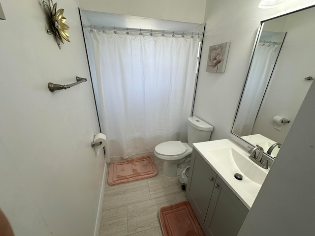 bathroom featuring toilet, tile flooring, and large vanity