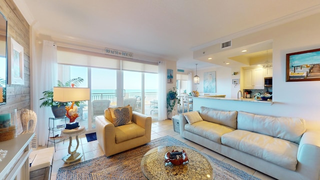 tiled living room featuring ornamental molding and a water view