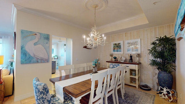 tiled dining area featuring ornamental molding, a notable chandelier, and a raised ceiling