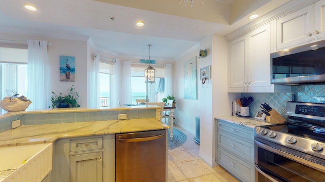 kitchen featuring pendant lighting, light tile flooring, stainless steel appliances, light stone counters, and tasteful backsplash