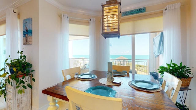 dining area featuring a water view and crown molding