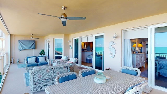 view of terrace with a water view, an outdoor living space, and ceiling fan