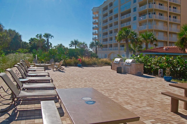 view of patio with area for grilling and a balcony