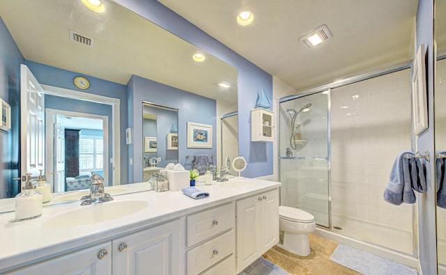 bathroom featuring tile flooring, toilet, a shower with door, and dual bowl vanity