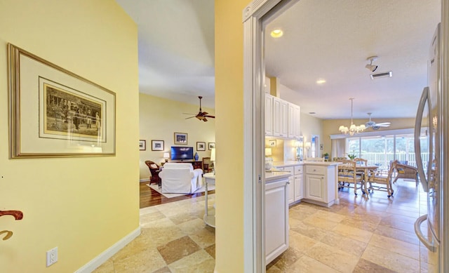 hallway featuring a chandelier and light tile floors