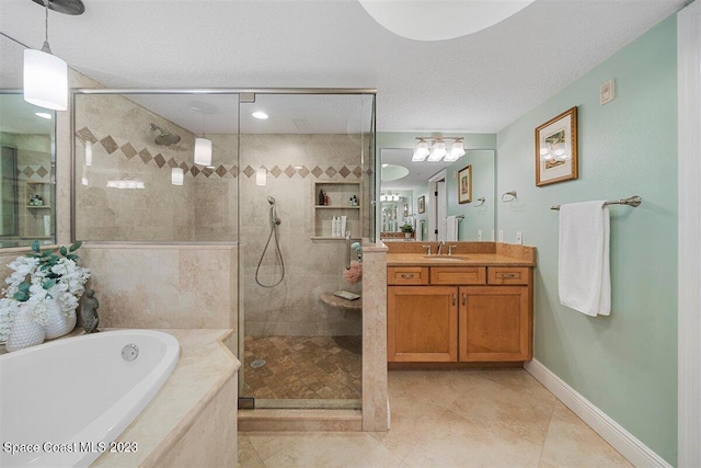 bathroom featuring a textured ceiling, tile floors, vanity with extensive cabinet space, and shower with separate bathtub