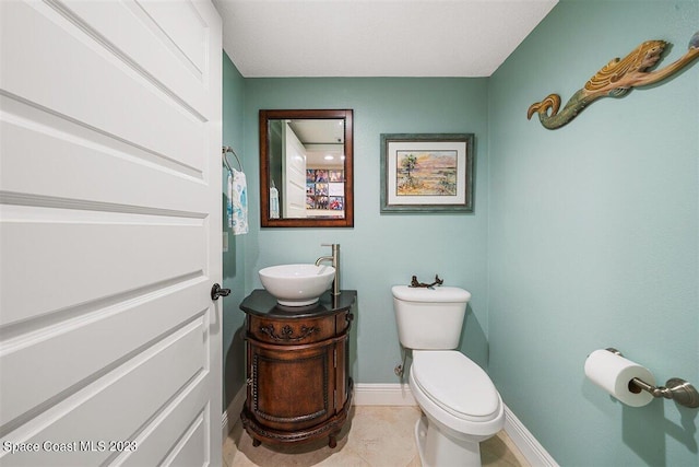 bathroom with tile flooring, vanity with extensive cabinet space, and toilet