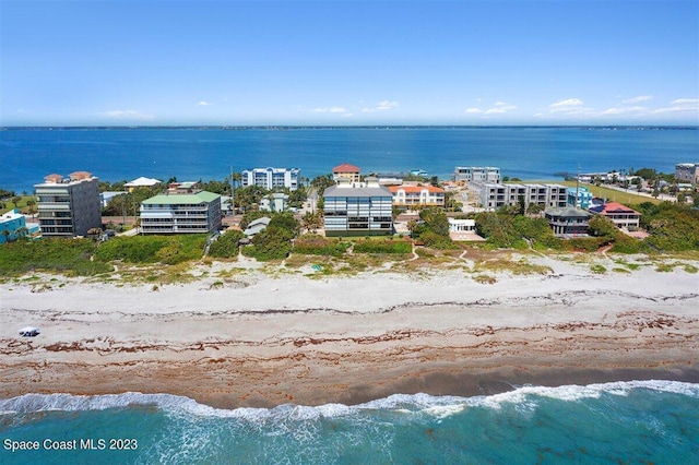 birds eye view of property with a water view and a view of the beach