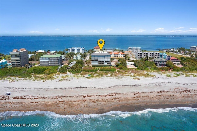 drone / aerial view featuring a water view and a view of the beach