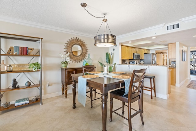 dining area featuring ornamental molding, light tile floors, and a textured ceiling