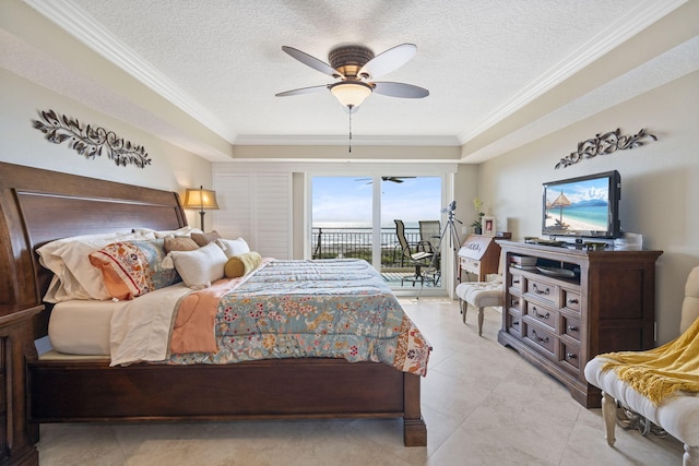 tiled bedroom featuring access to outside, a tray ceiling, ornamental molding, ceiling fan, and a textured ceiling