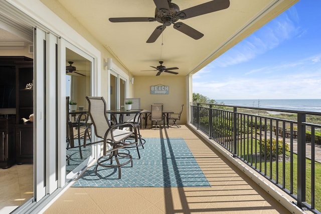 balcony with a water view and ceiling fan